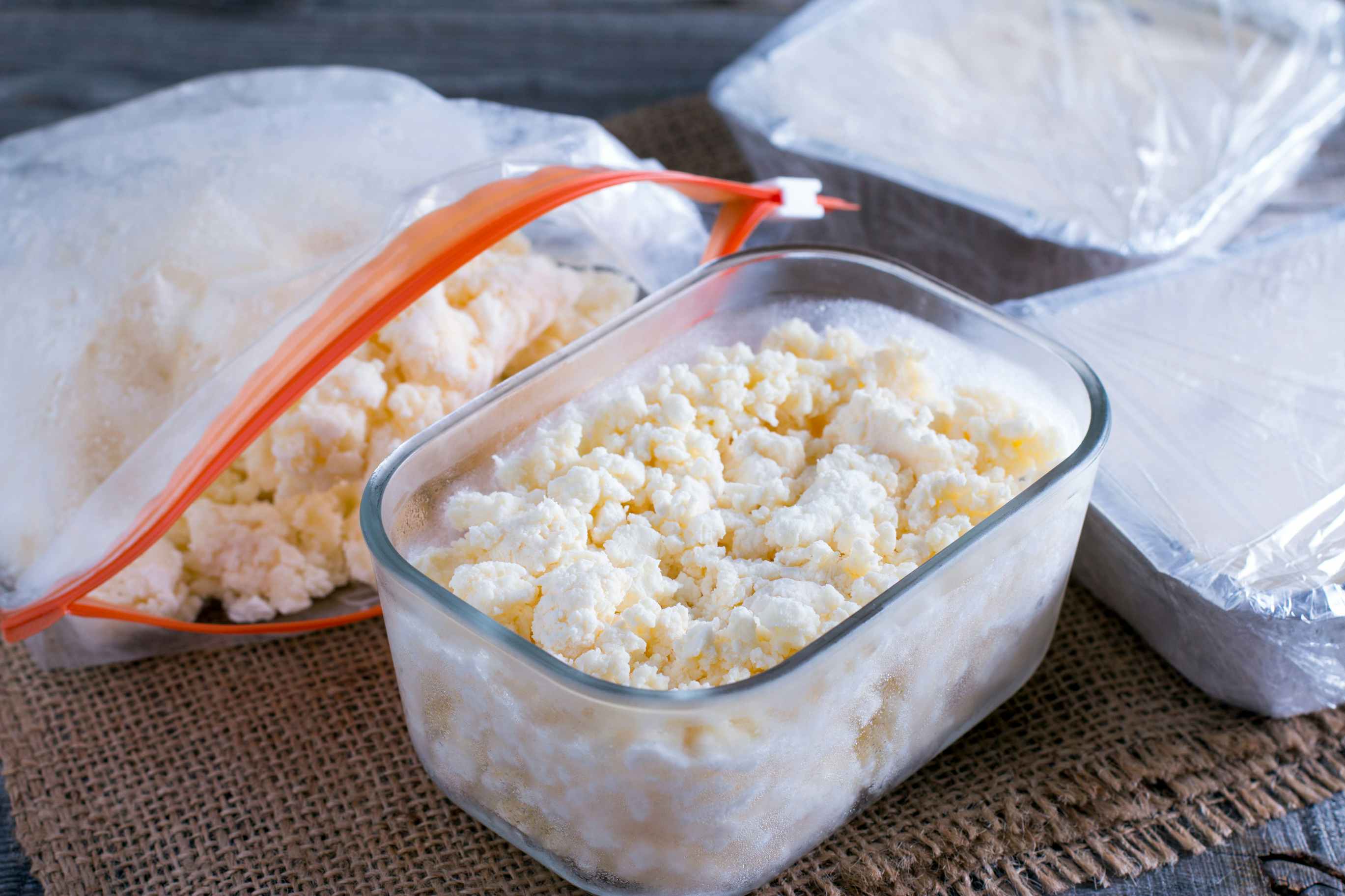 A container of cottage cheese next to a bag on a counter