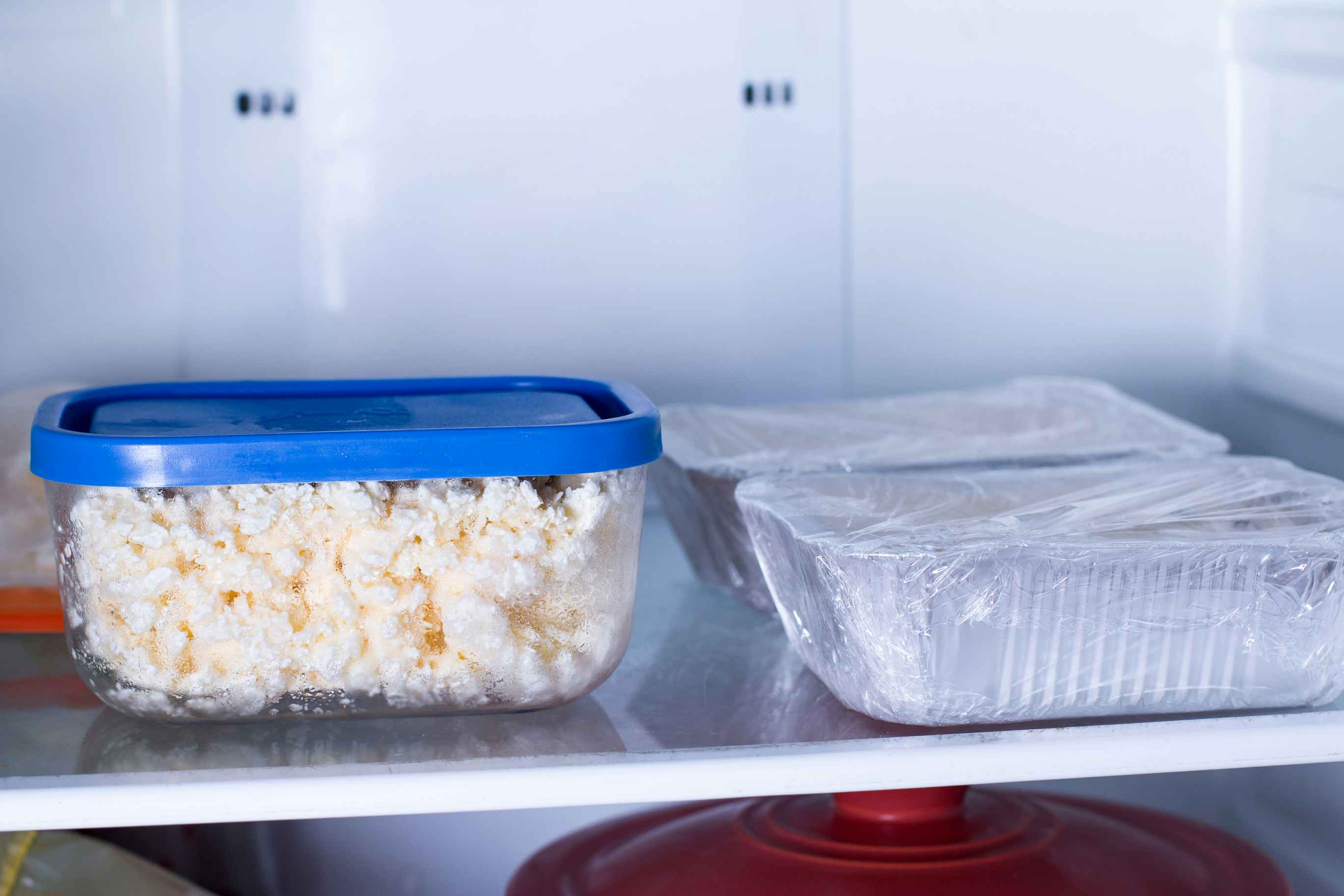 A container of frozen cottage cheese defrosting in the fridge