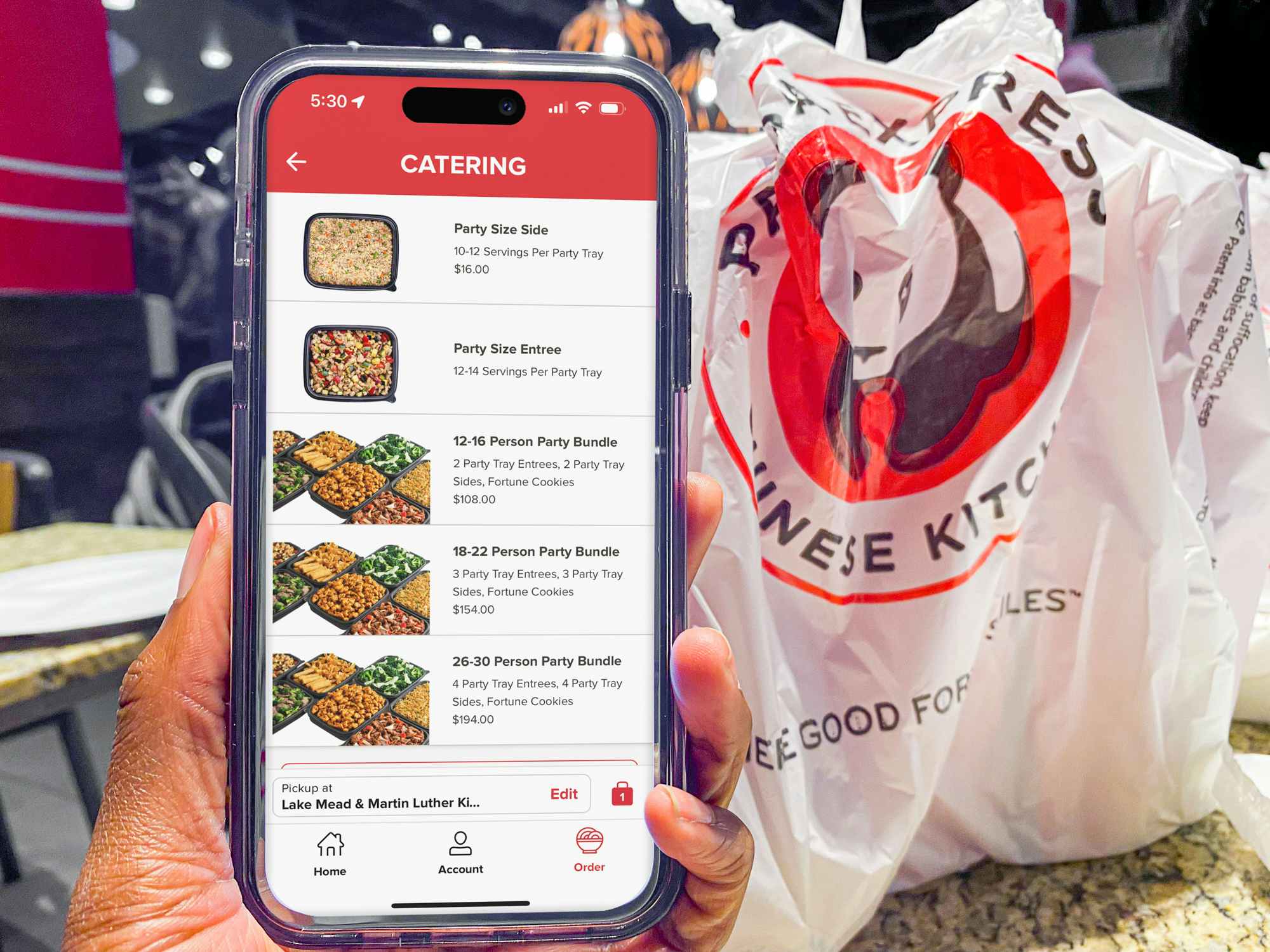 Someone holding a phone displaying the Panda Express app's page for catering