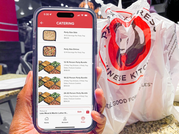 Someone holding a phone displaying the Panda Express app's page for catering