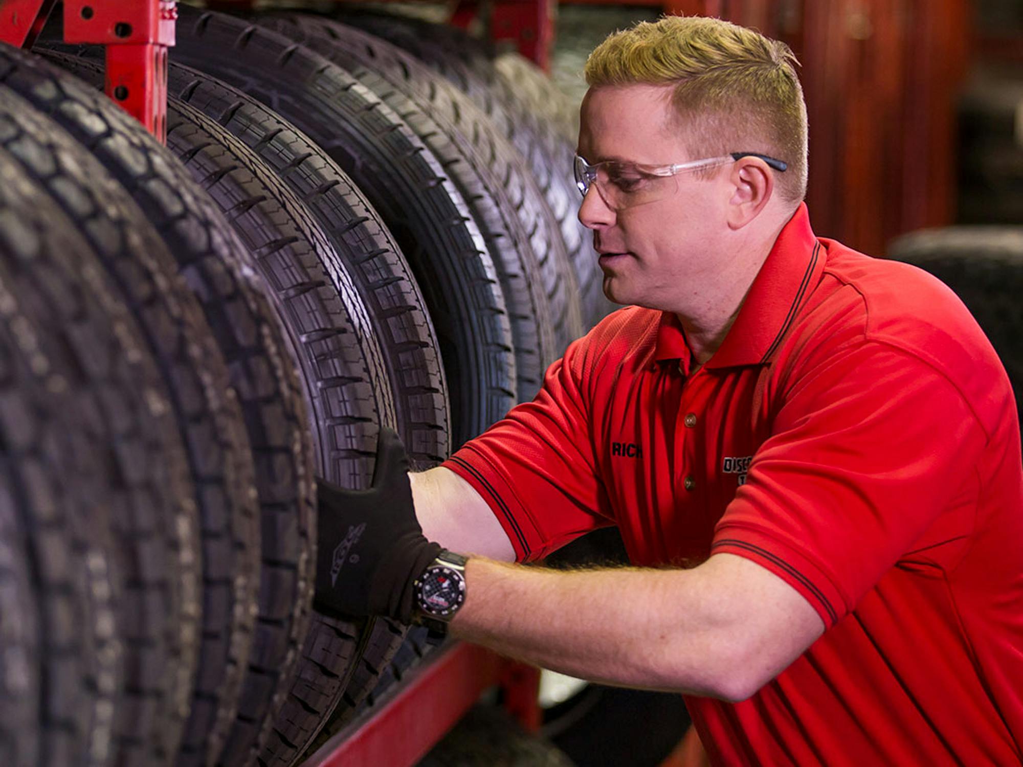 A Discount Tire employee taking a tire from a shelf
