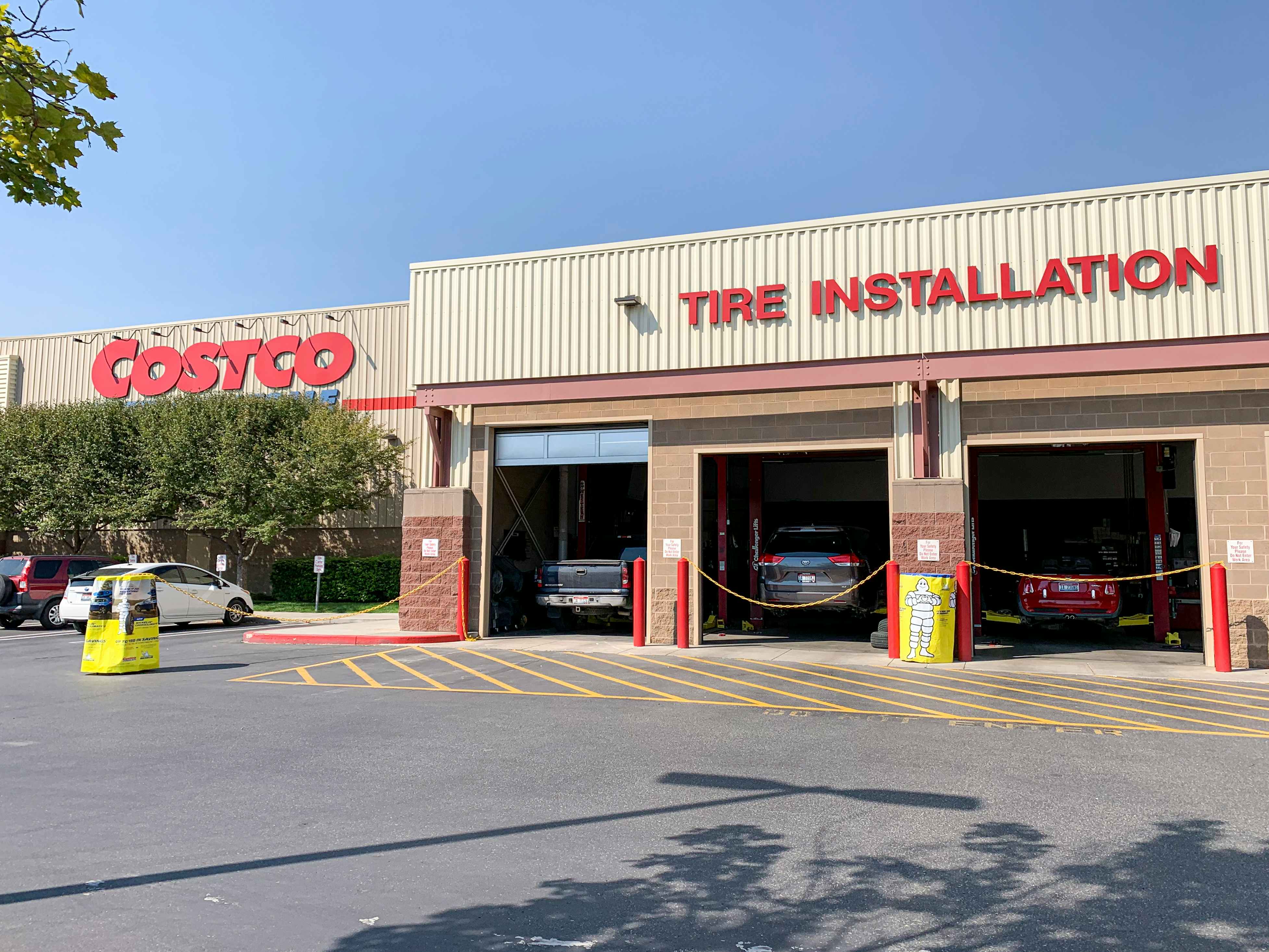 The outside of a Costco Tire Installation garage with cars inside.