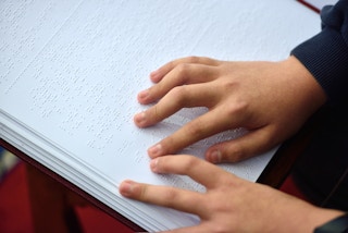 Girl reading a braille book