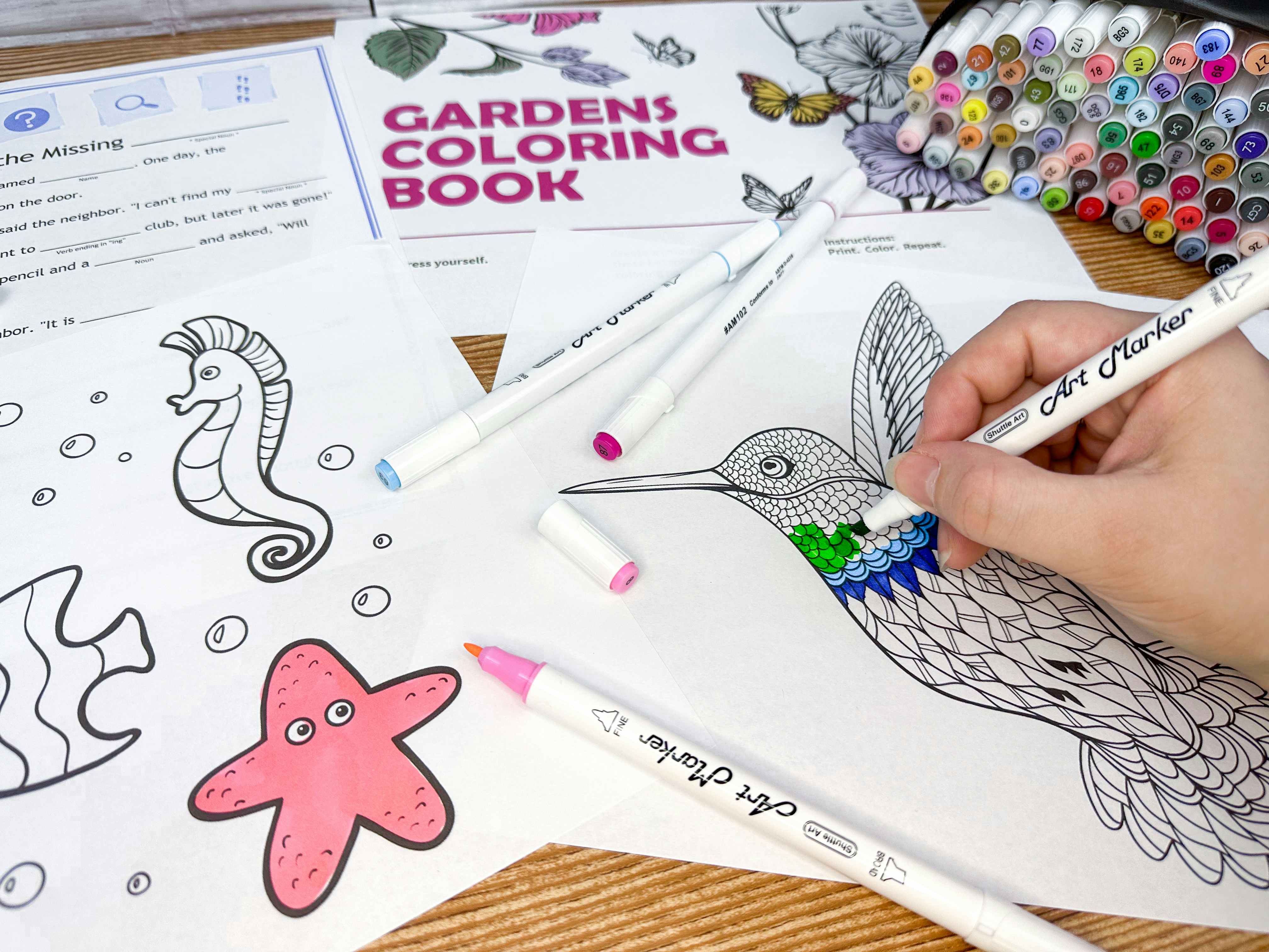 Coloring pages and activity print outs from the Microsoft Virtual camp printables, with art markers and someone coloring in a hummingbird coloring page