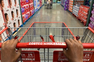 A Costco shopping cart being pushed down an aisle