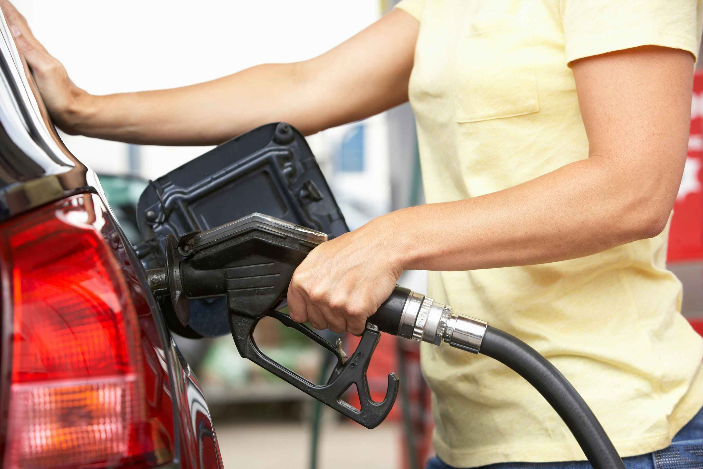 person at gas station putting fuel in car