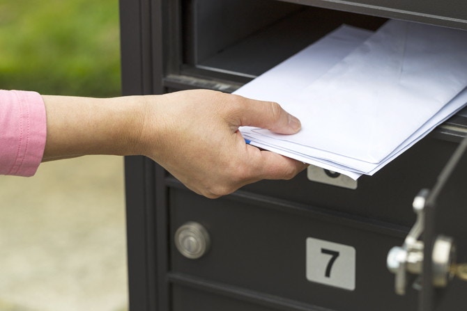 someone putting letters in mailbox