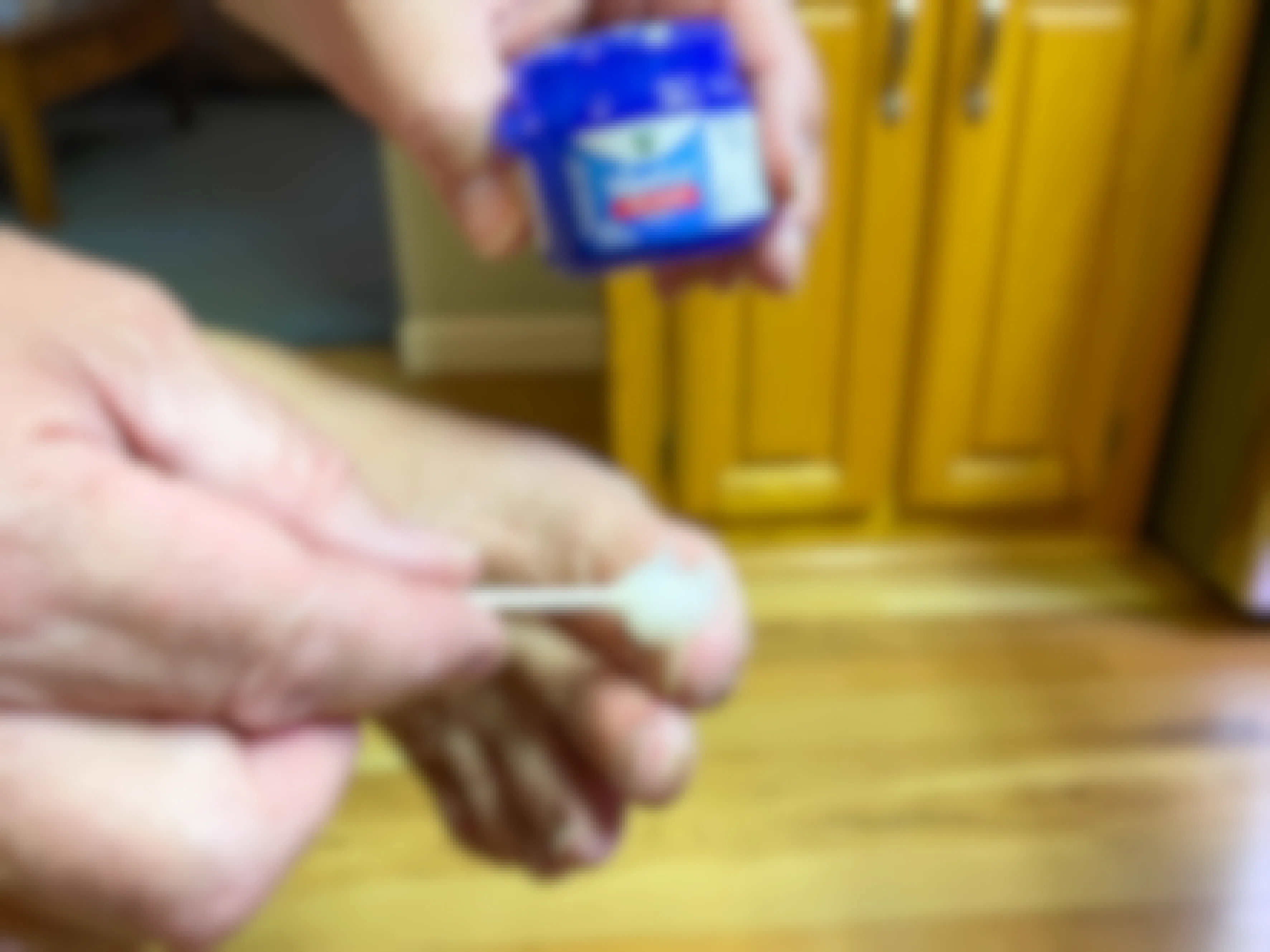 close up of someone putting vicks vapor rub on toes with qtip