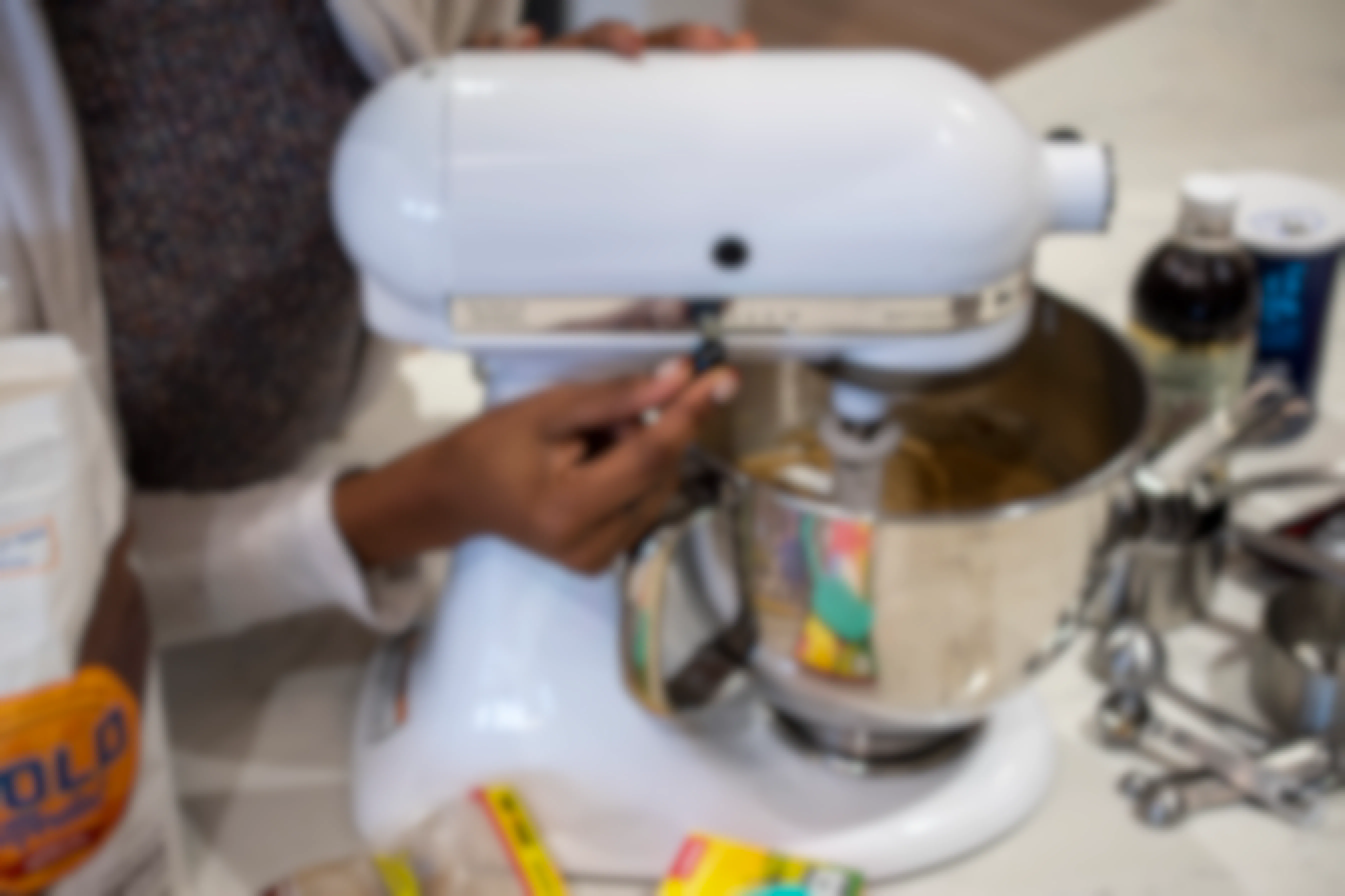 A person turning on a KitchenAid mixer