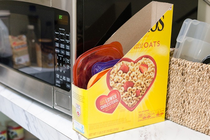 Hold plastic lids in a cereal box.