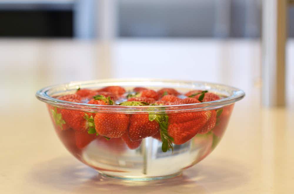 bowl of strawberries soaking in vinegar bath