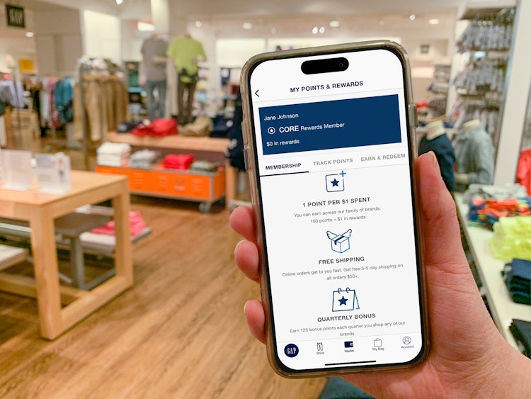 Someone holding up their phone displaying the GAP rewards app inside a GAP store.