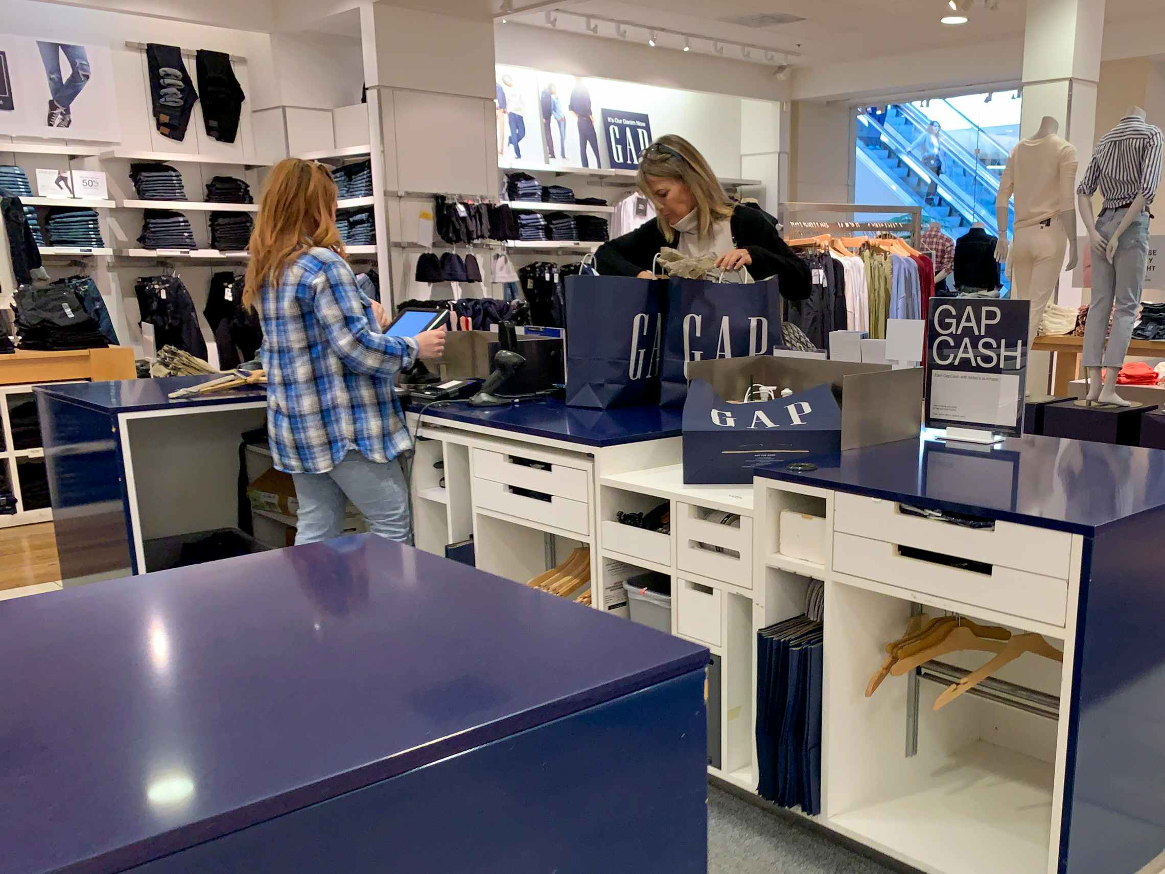Gap employee checking out a woman at a Gap counter.