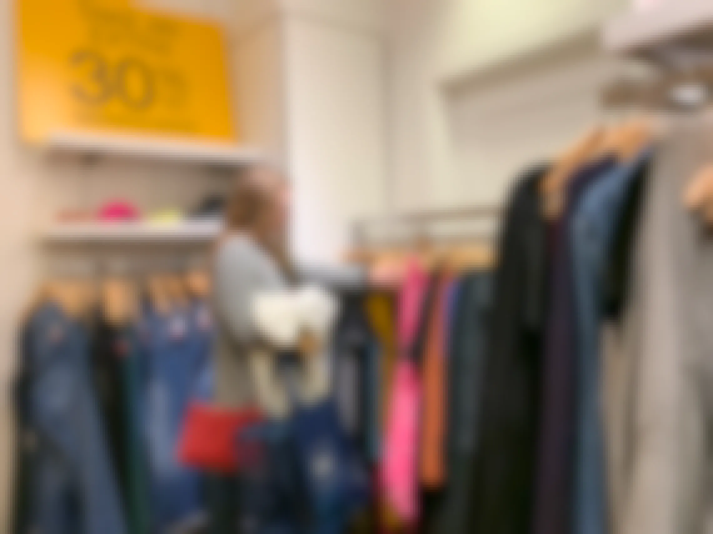 A woman searching through the women's clearance clothing rack at GAP.