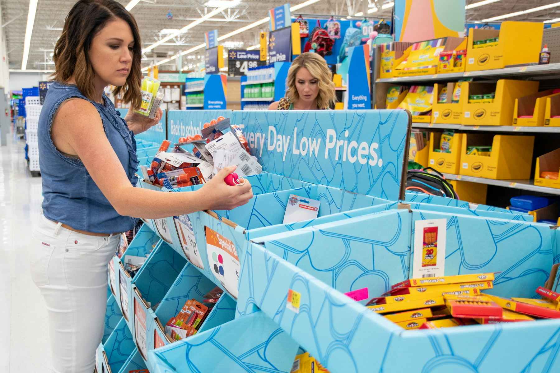 Two women shopping through the Back to School display shelves at Walmart.