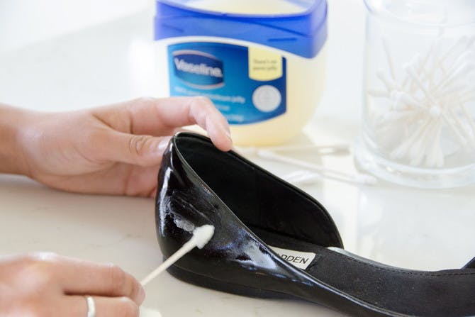 Someone removing scuffs on patent leather shoes with Vaseline.
