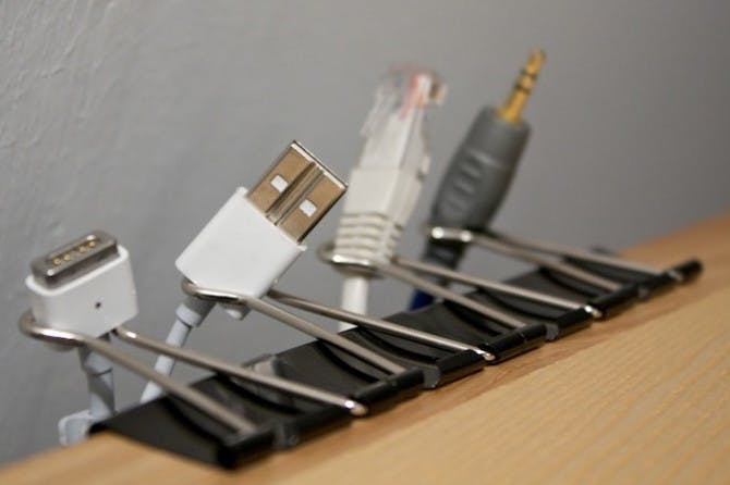 cords attached to binder clips on side of a table