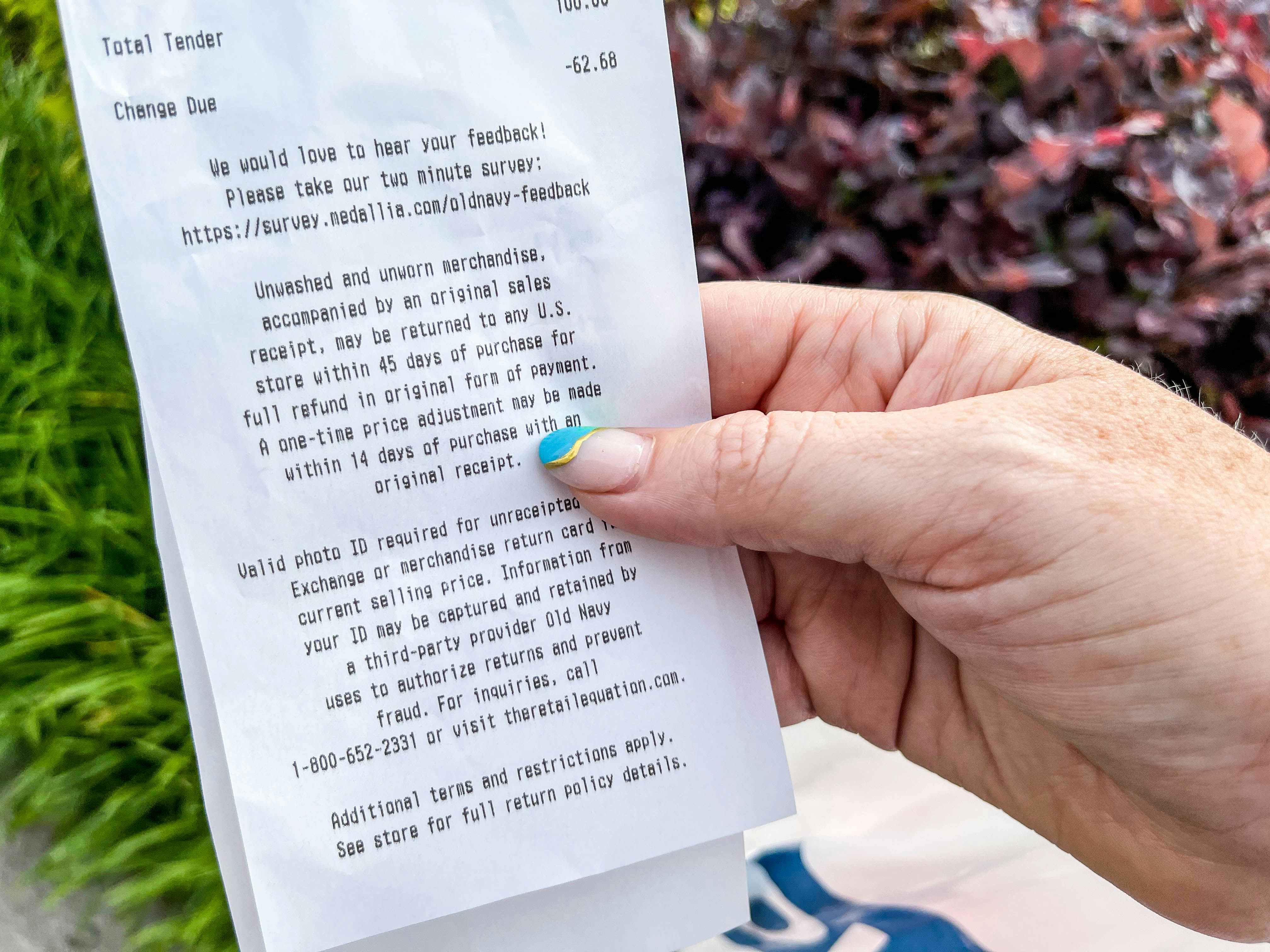 hand holding old navy receipt with return information