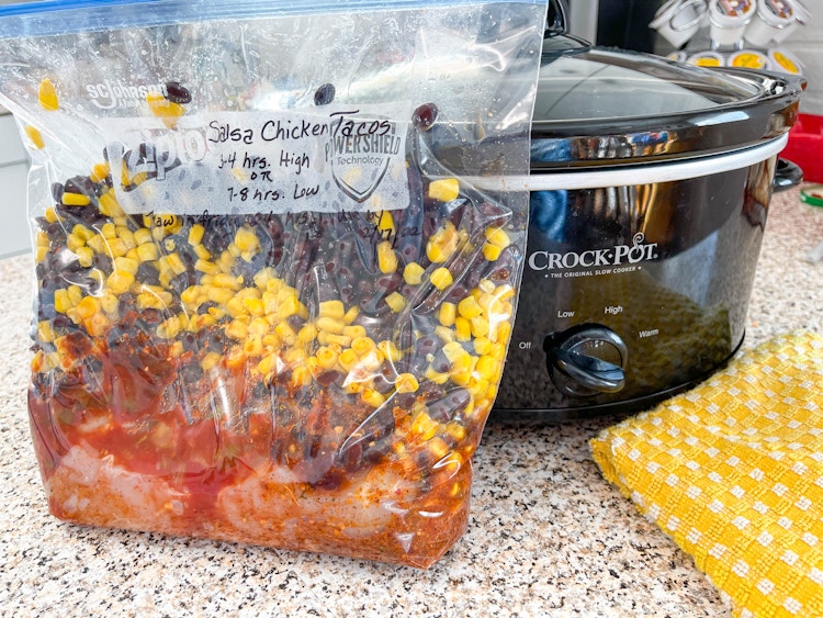 Ziploc bag with a freezer meal next to a crockpot