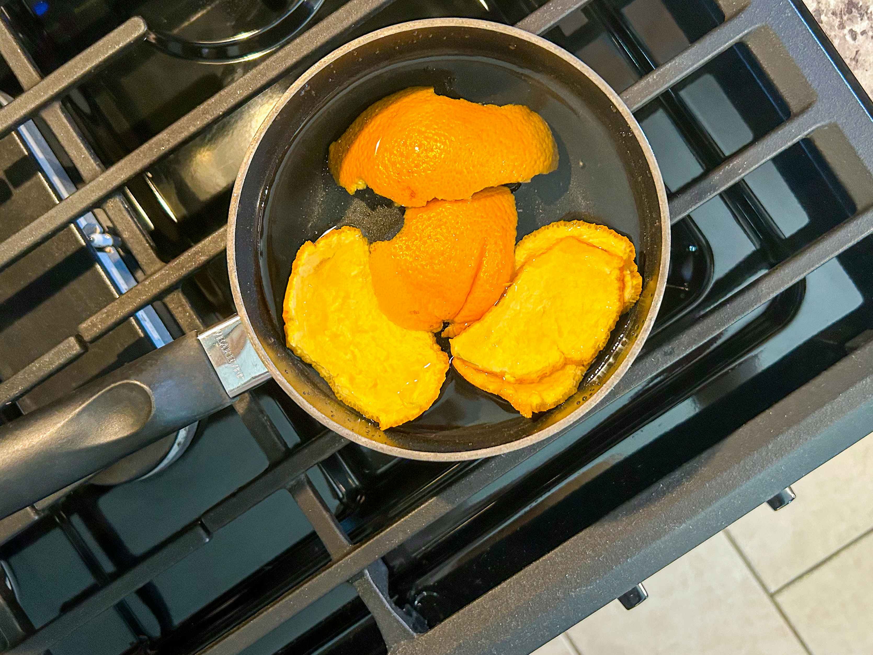 orange peels in a pot with water sitting on a stove