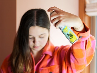 person using dry shampoo on their hair