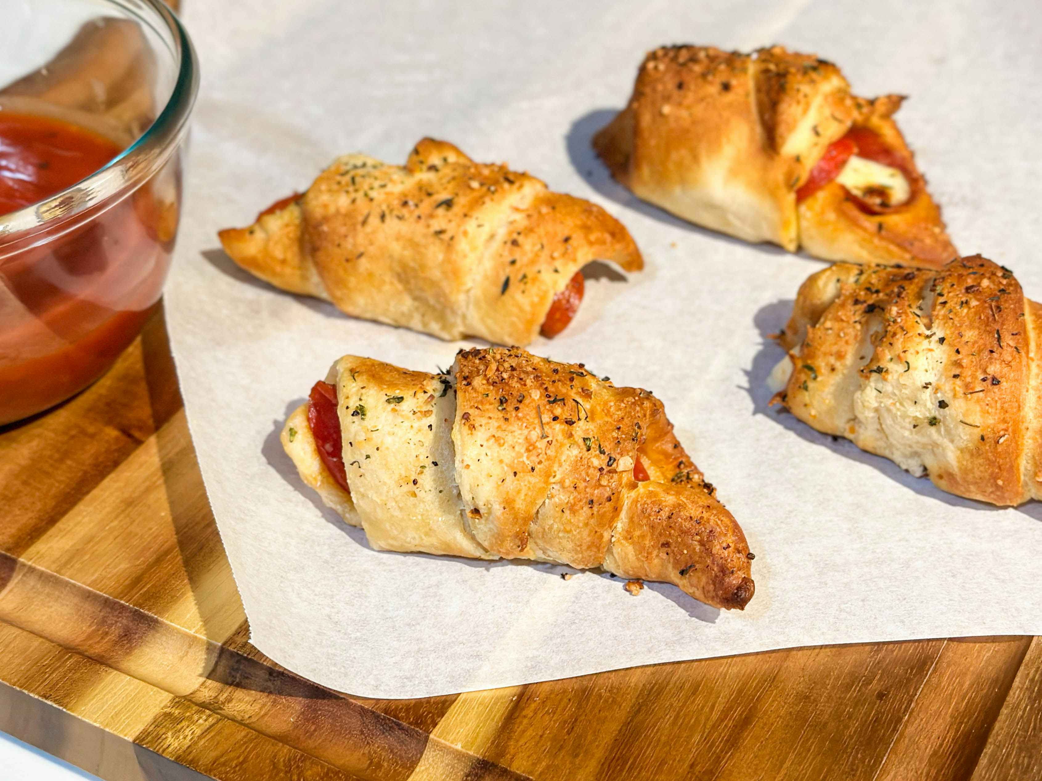 pizza like crescent rolls on a cutting board next to dip