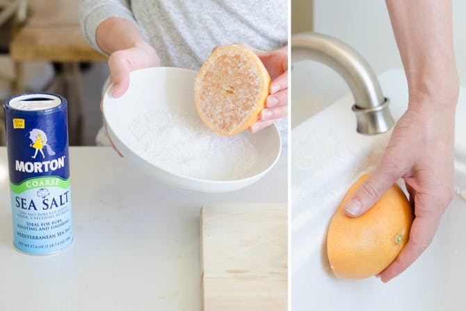 someone dipping half a grapefruit into a bowl of salt and using it to scrub a tub