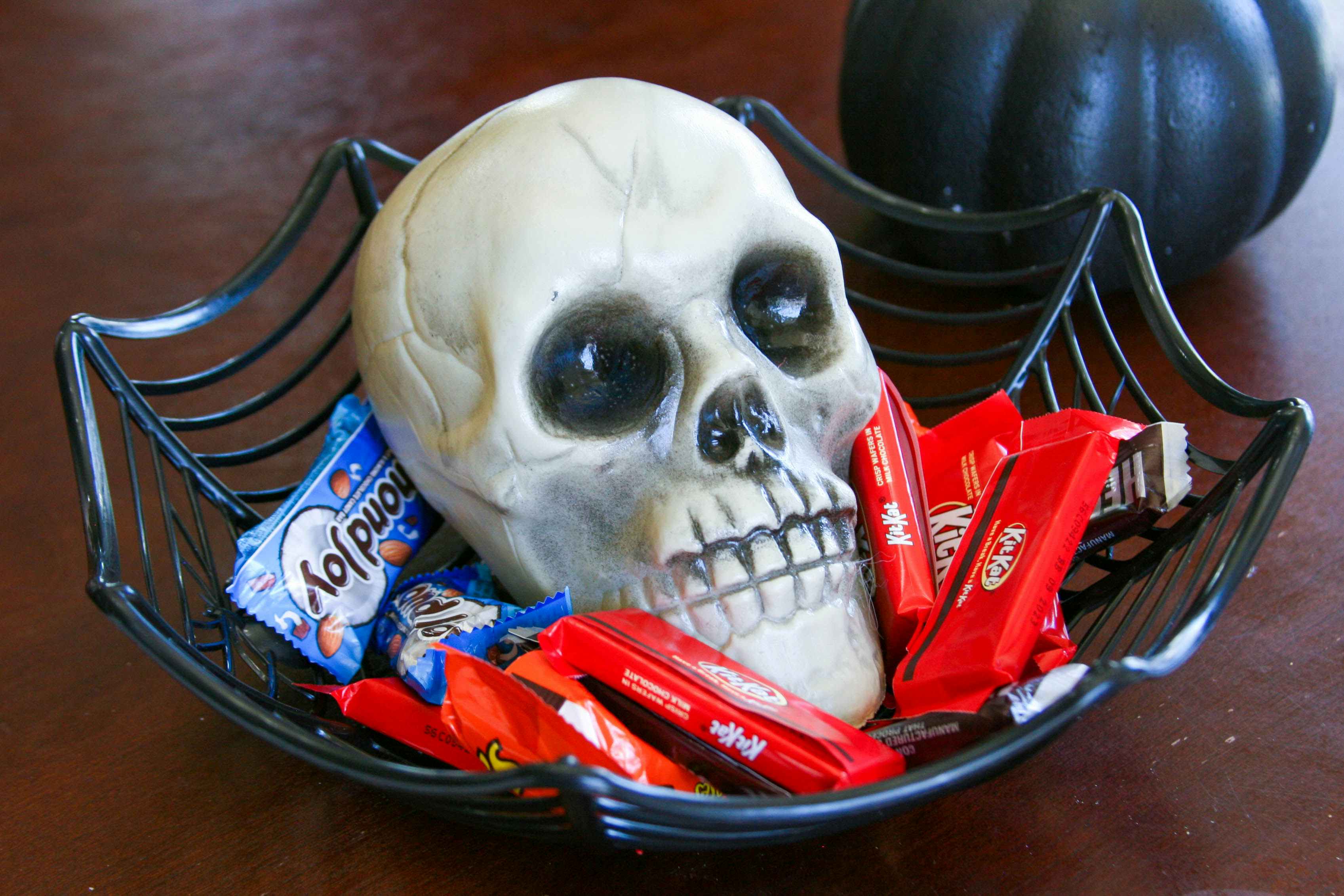 a skull inside a basket with candy in basket sitting on a table