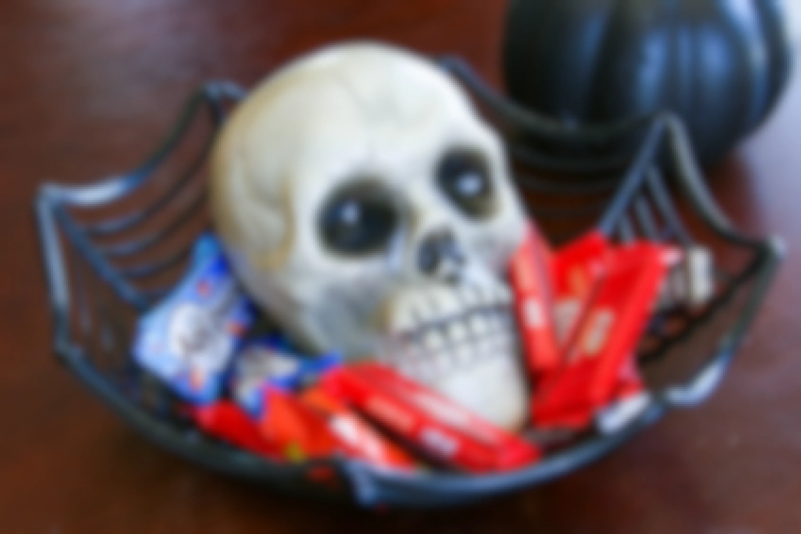 a skull inside a basket with candy in basket sitting on a table