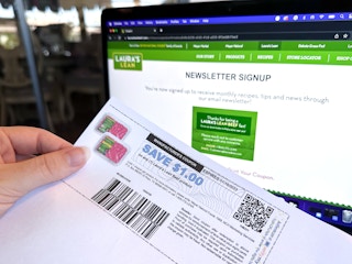 Someone holding a printed coupon for Laura's Lean Beef in front of their email newsletter signup webpage
