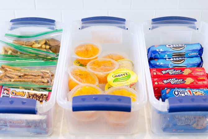 Three containers filled with lunch box sized snack foods.