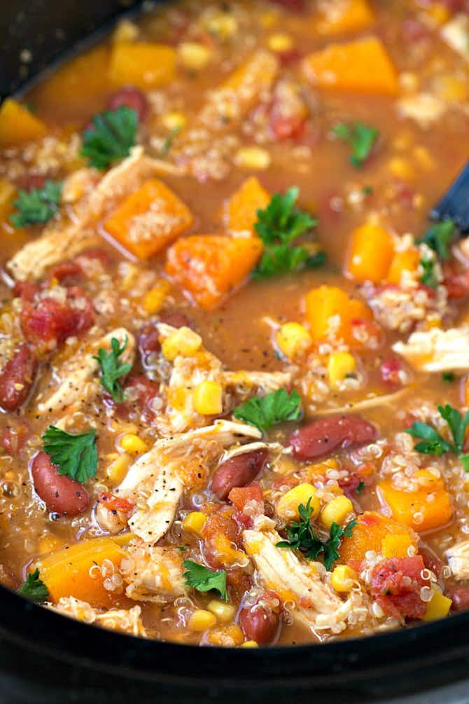 A slow cooker full of bean, butternut squash, corn and quinoa soup