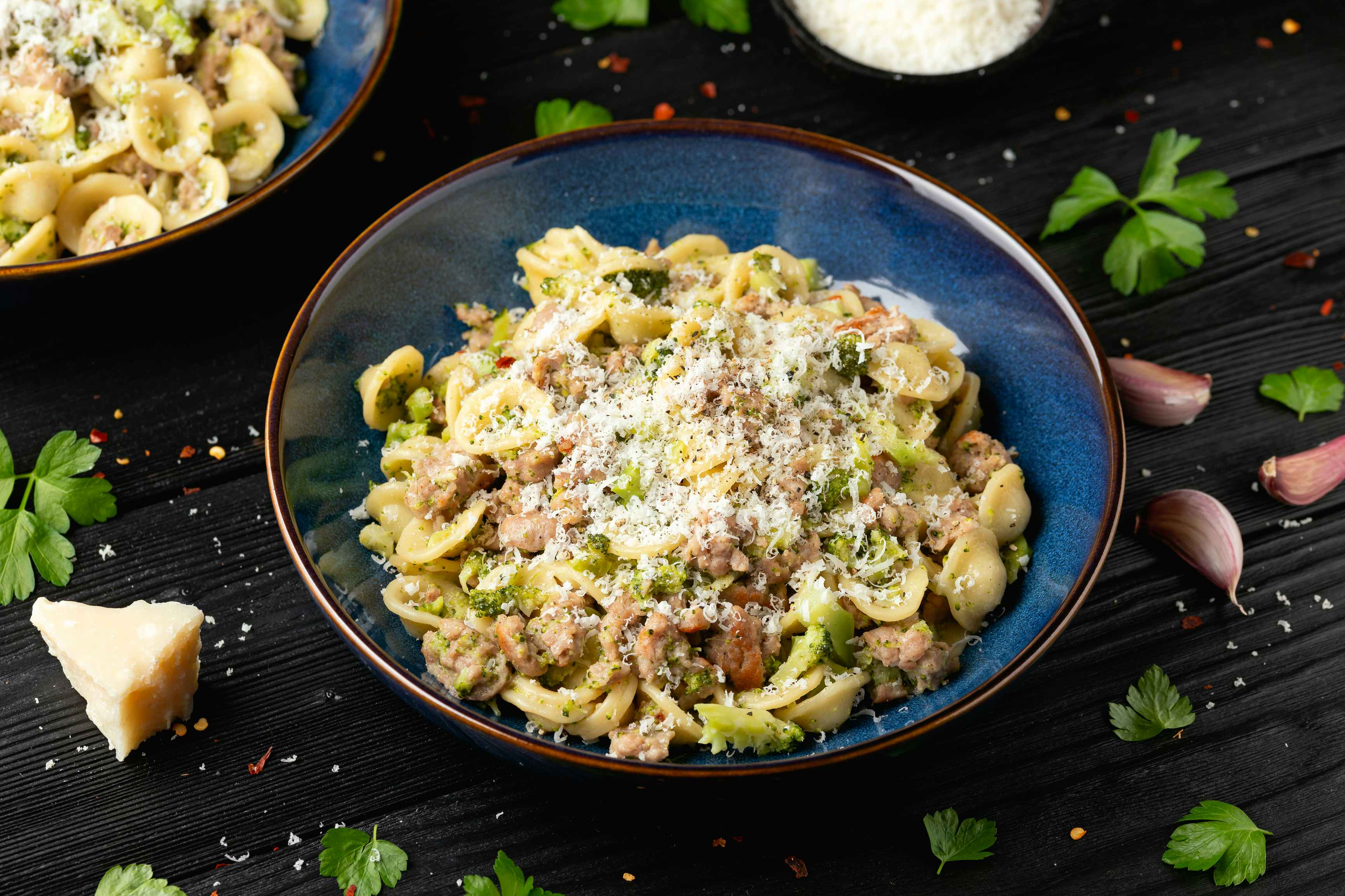 Orecchiate pasta with broccoli and sausage covered in parmesean cheese