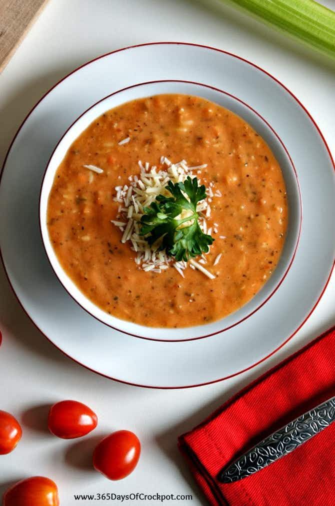 A bowl of tomato soup topped with parmesan cheese.