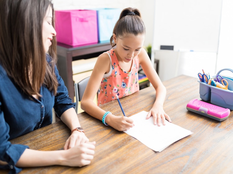 Tutor helping student with schoolwork at home