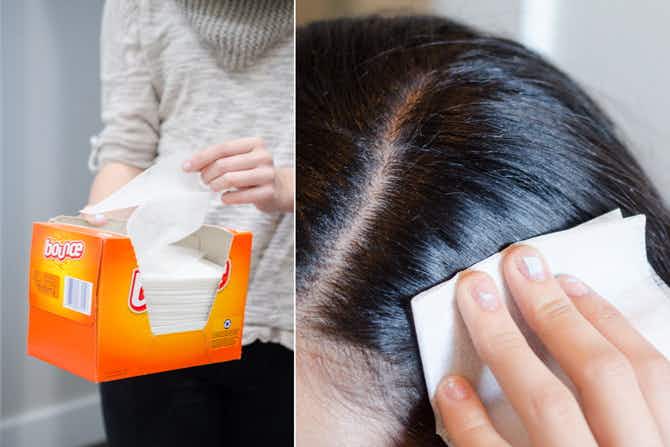 A woman using a dryer sheet to prevent static in her hair.