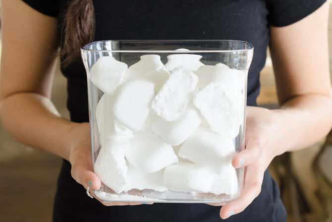 homemade dishwasher tabs in clear container being held 