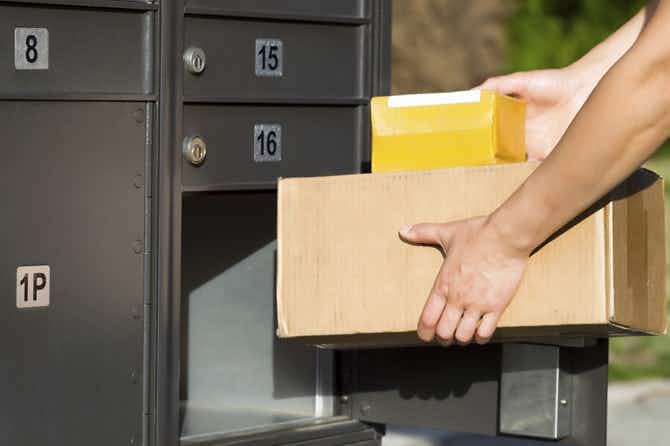 a person placing packages into a mailbox slot