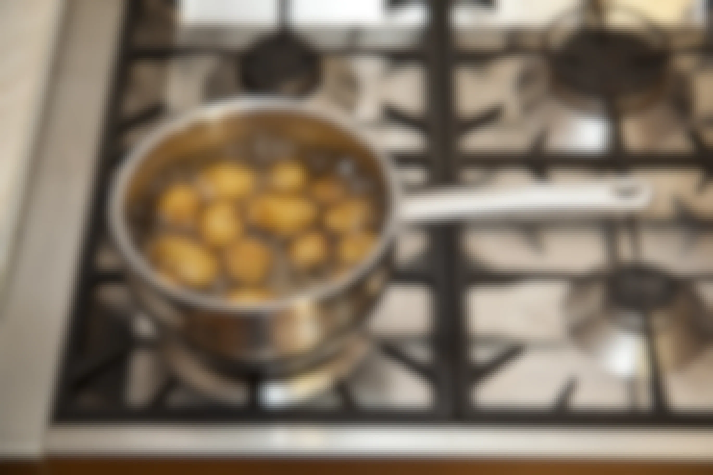 A pot of potatoes boiling on a stove.