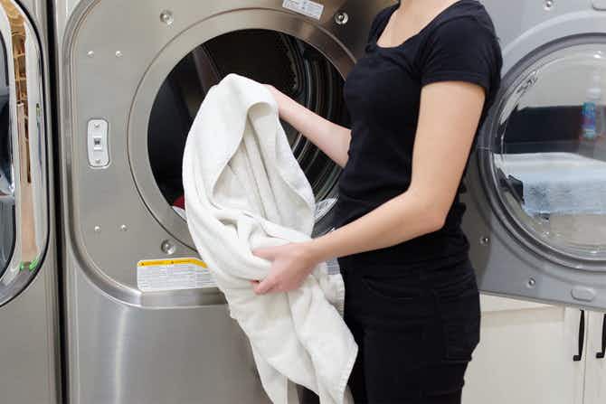 someone putting towel in dryer