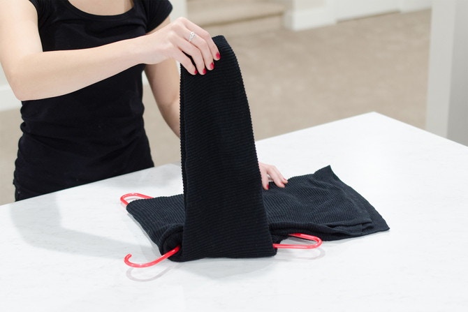 Hanging sweaters like this will prevent them from falling off or getting stretched out.
