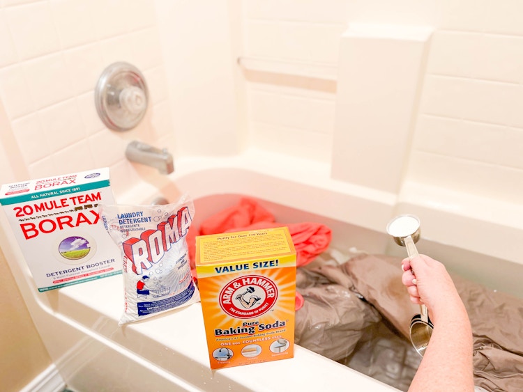 bath tub filled with water and laundry with cleaning products to strip laundry