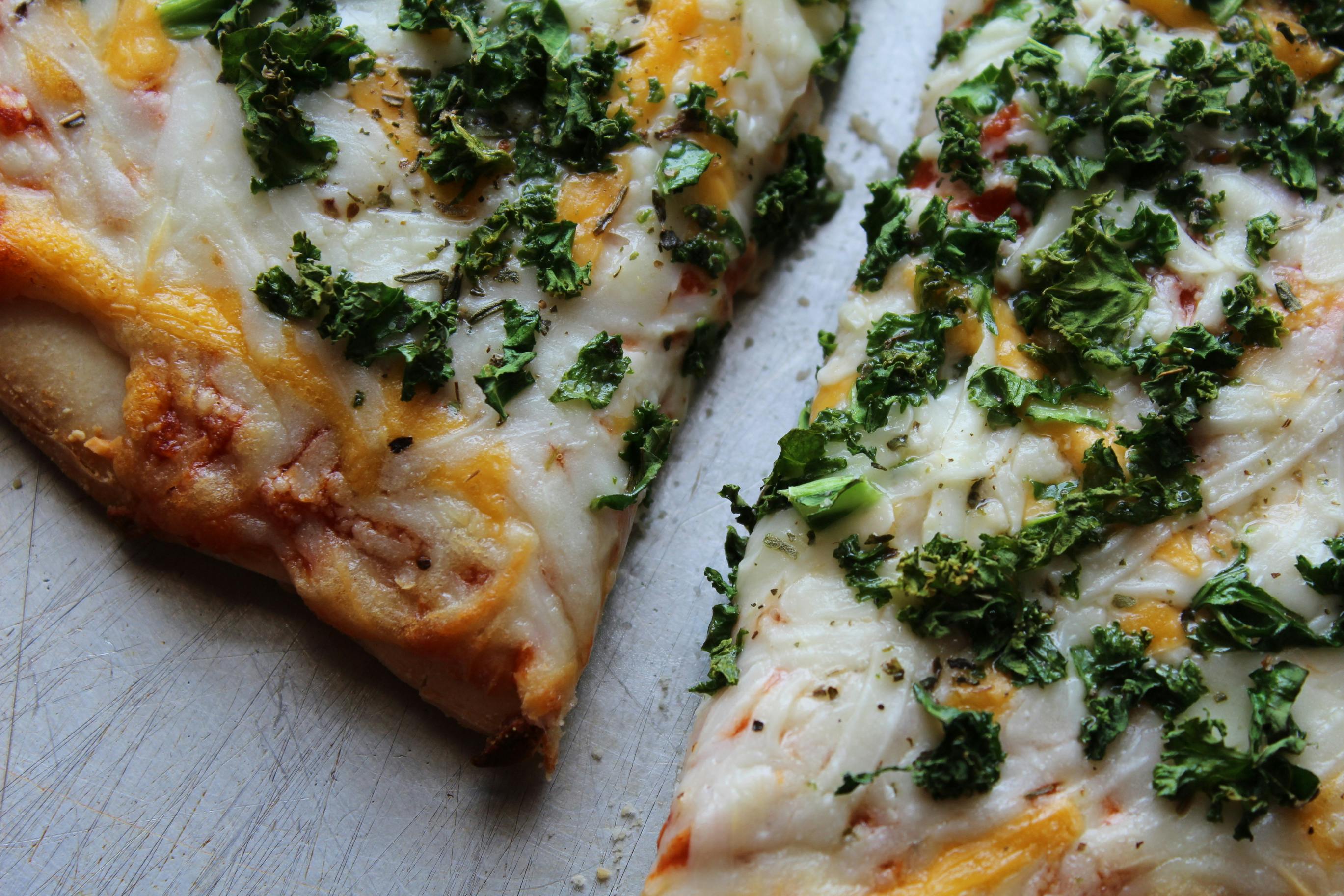 A close up of a pizza with kale on it
