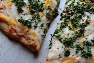 A close up of a pizza with kale on it