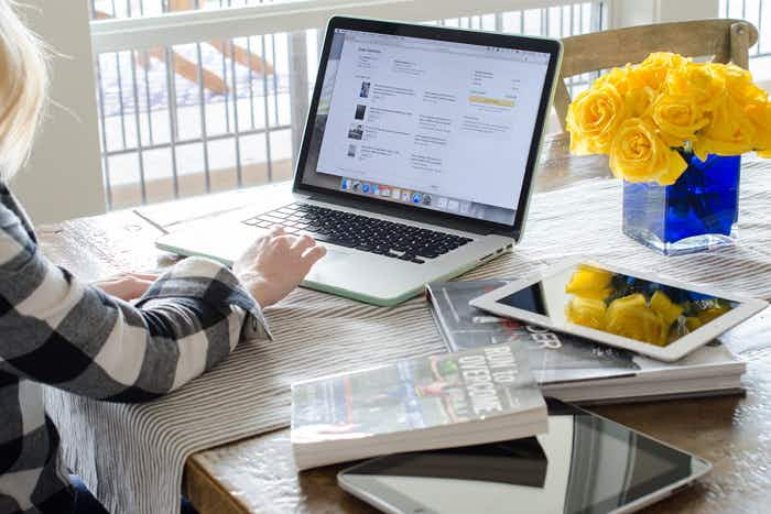 A person typing on a laptop on a table.