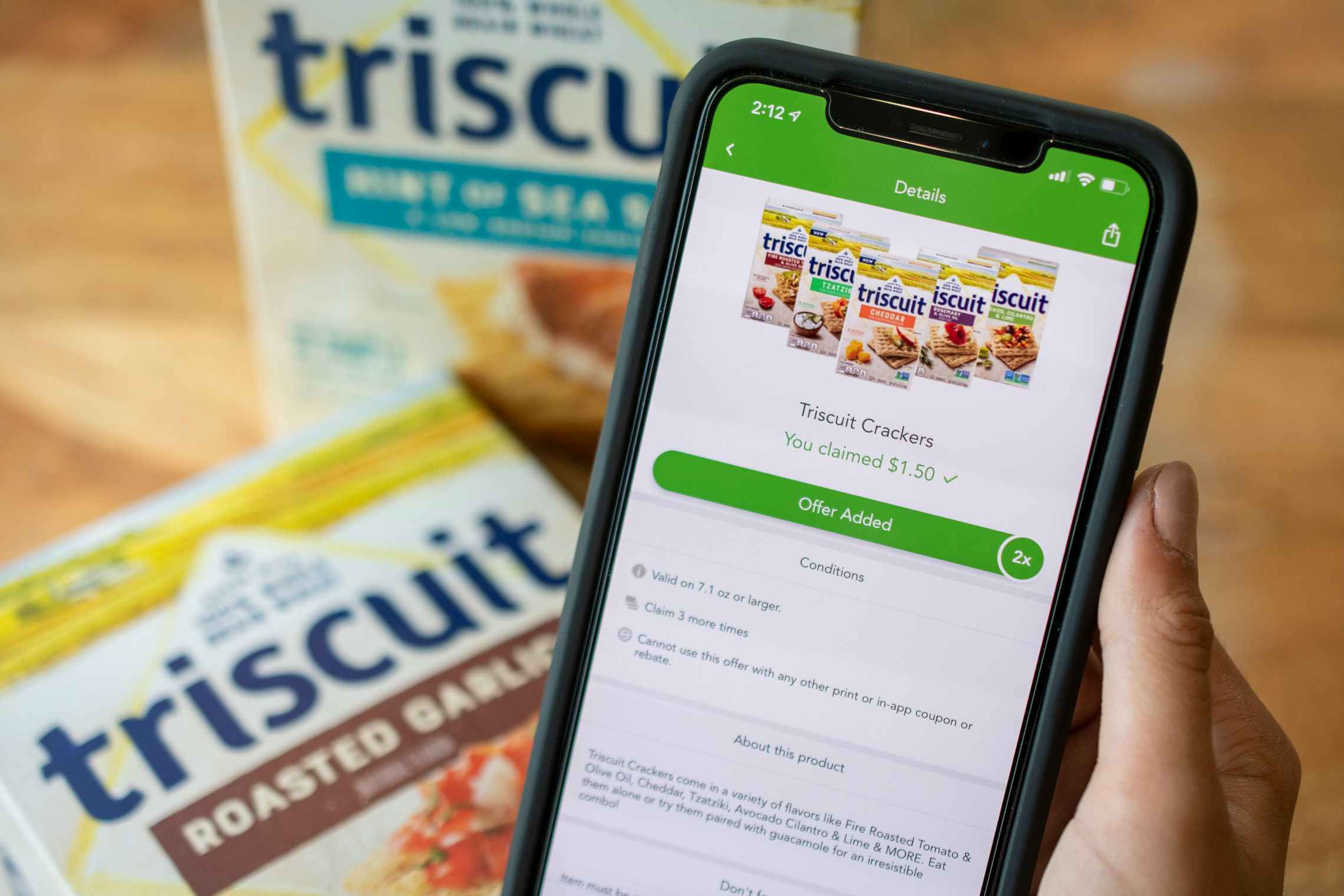 A Triscuit cracker deal on a cell phone with two boxes of crackers in the background
