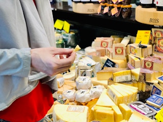 A woman sampling cheese at whole foods
