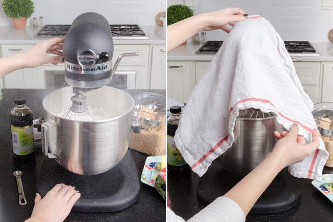 Someone draping a towel over a stand mixer to stop ingredients from splashing out.