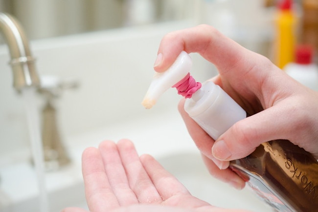 person pumping hand soap with rubber band to control flow