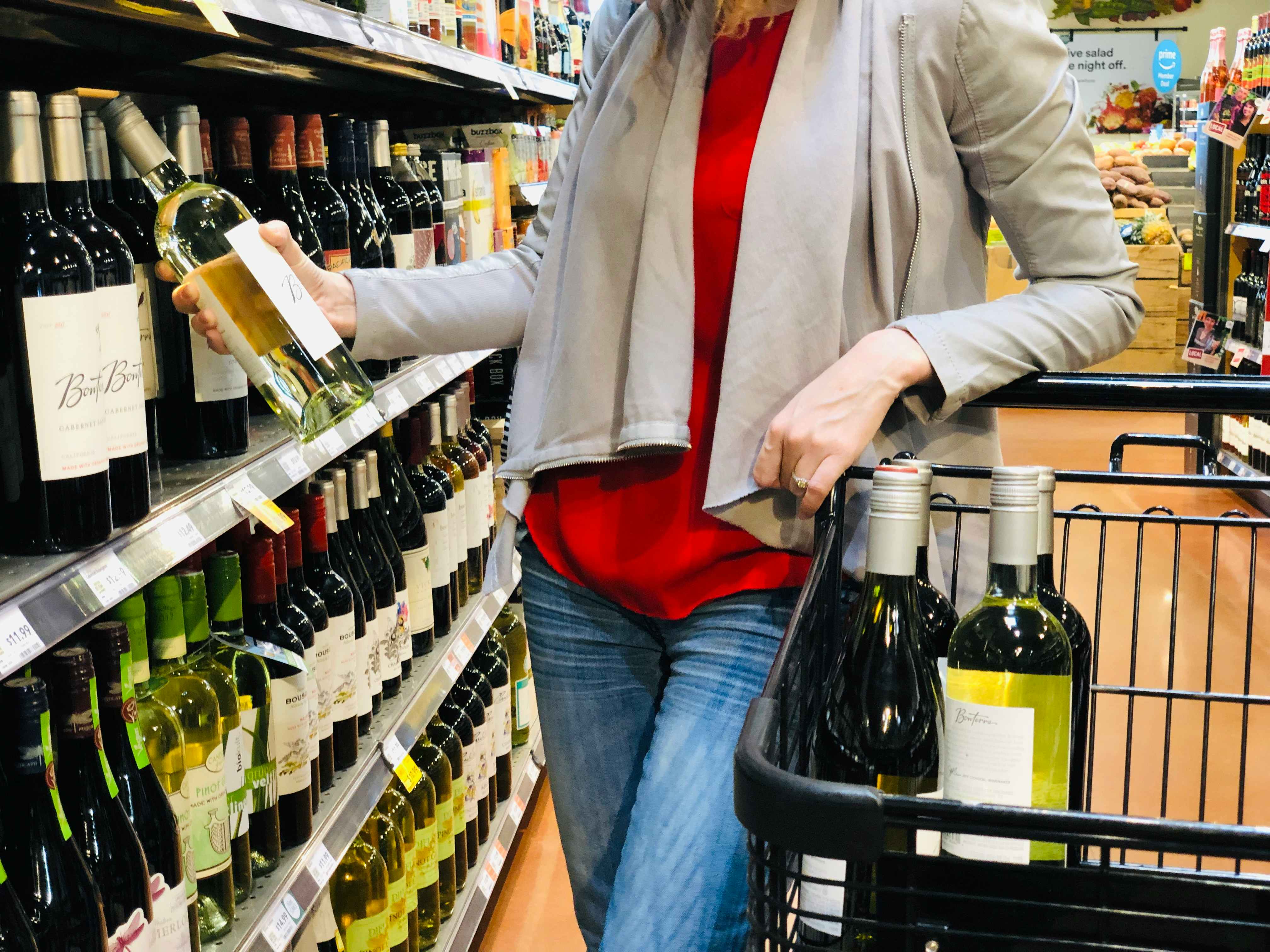 A woman shopping for wine at whole foods